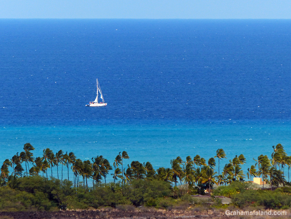 A sailboat passes Kiholo on the Big Island, Hawaii