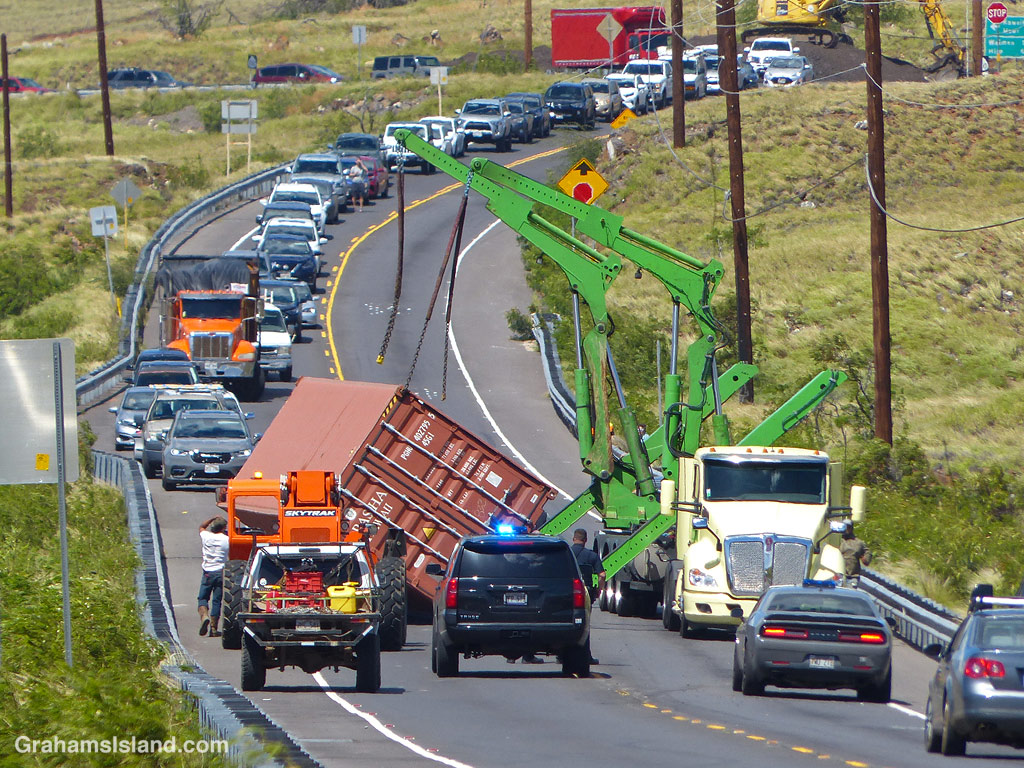 A semi-truck trailer, blown over on a highway in Hawaii, is recovered