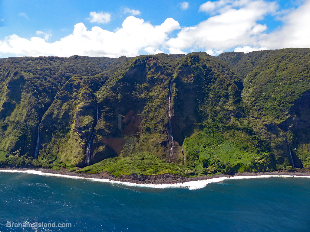 Waterfalls plunge intot he ocean along the North Kohala Coast, Hawaii