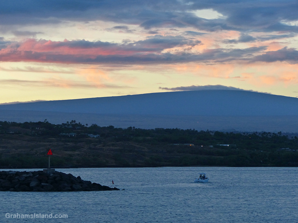 A small boat leaves Kawaihae harbor in the early morning